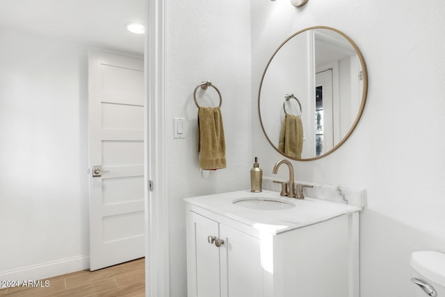 bathroom with vanity, toilet, and wood-type flooring