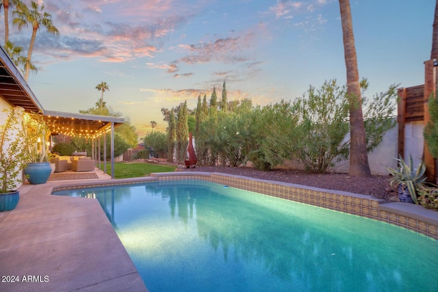 pool at dusk featuring a patio