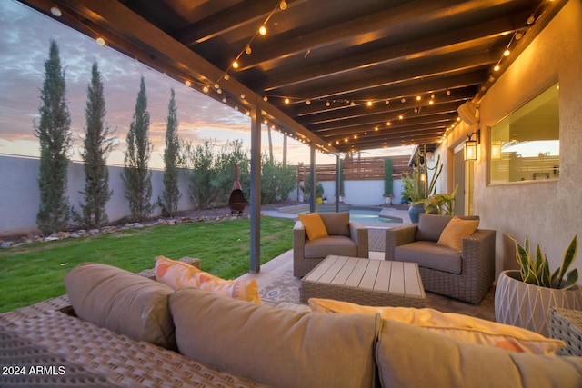 patio terrace at dusk with a jacuzzi, a yard, and an outdoor hangout area