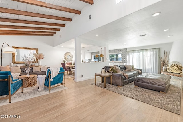 living room with vaulted ceiling with beams, wood ceiling, and light wood-type flooring