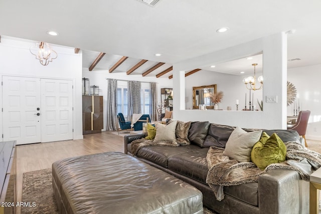 living room featuring vaulted ceiling with beams, light hardwood / wood-style floors, and a notable chandelier