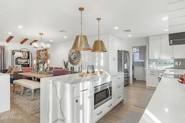 kitchen with white cabinets, light wood-type flooring, stainless steel appliances, and hanging light fixtures