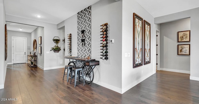 corridor featuring wood finished floors and baseboards