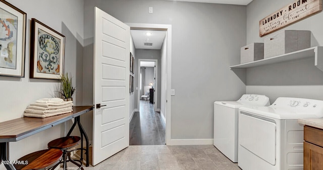 laundry area with washing machine and clothes dryer and light hardwood / wood-style flooring