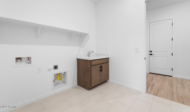 clothes washing area featuring electric dryer hookup, sink, washer hookup, and light hardwood / wood-style floors