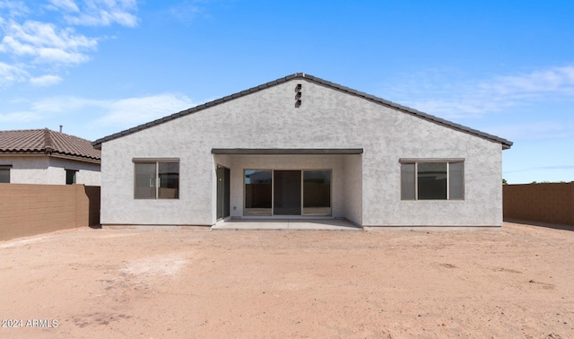 rear view of house featuring a fenced backyard, a patio, and stucco siding