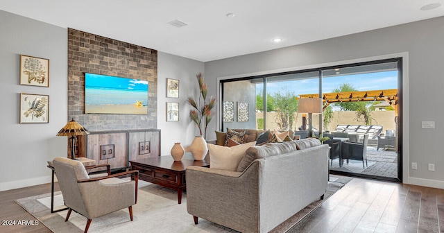 living area featuring visible vents, baseboards, and wood finished floors