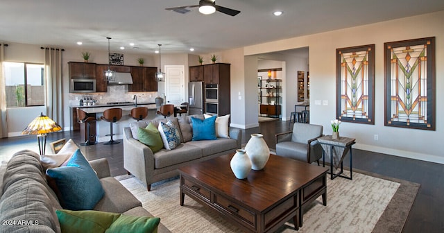 living room featuring light hardwood / wood-style floors, ceiling fan, and sink