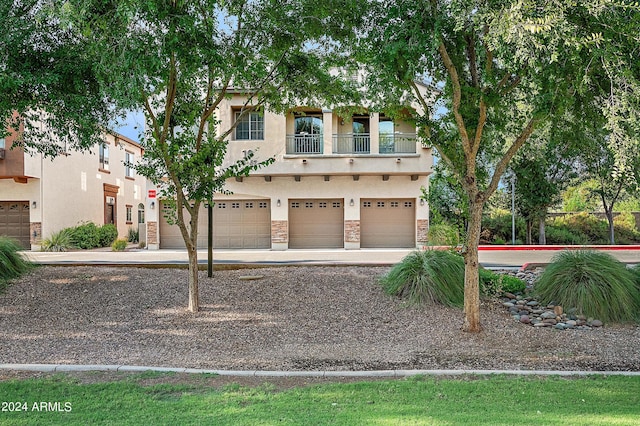 view of front of property with a garage and a balcony