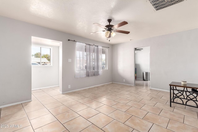 tiled spare room featuring ceiling fan and a textured ceiling