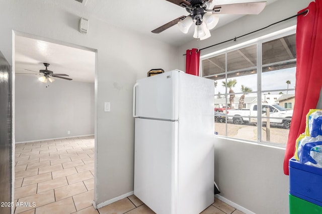 kitchen with light tile patterned flooring, white fridge, and ceiling fan