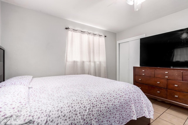 bedroom featuring ceiling fan, a closet, and light tile patterned floors