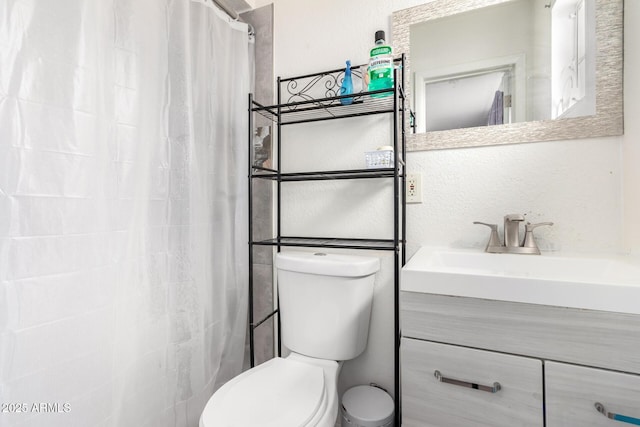 bathroom with vanity, curtained shower, and toilet