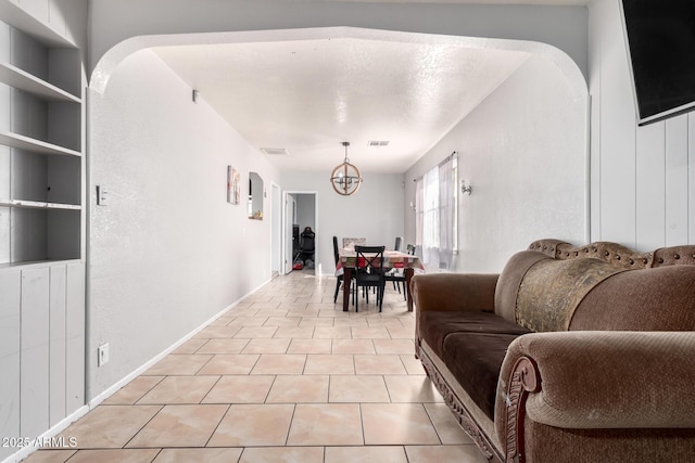 tiled dining space featuring built in features and a notable chandelier