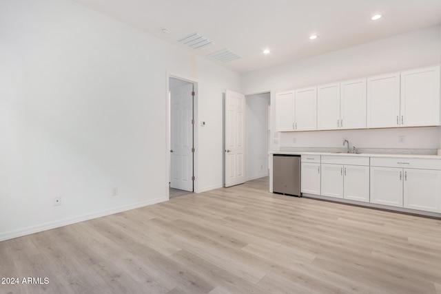 kitchen featuring stainless steel dishwasher, sink, white cabinetry, and light hardwood / wood-style floors