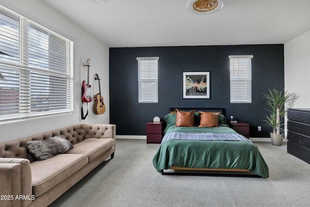 bedroom with an accent wall, visible vents, baseboards, and carpet floors