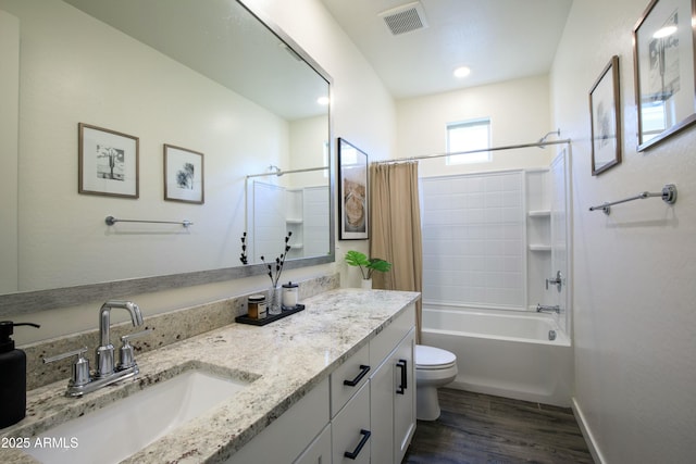 bathroom with vanity, wood finished floors, visible vents, toilet, and shower / tub combo with curtain