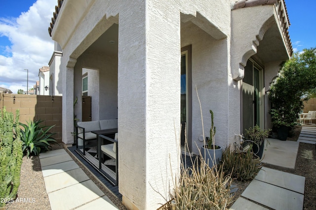 view of home's exterior with stucco siding and fence