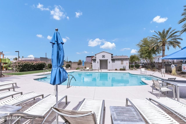 pool featuring fence and a patio area