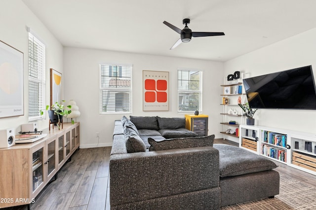 living area with a ceiling fan, wood finished floors, and baseboards