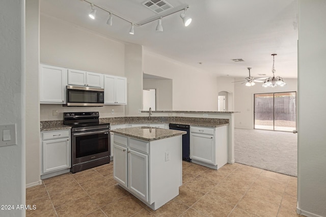 kitchen featuring light carpet, white cabinets, ceiling fan with notable chandelier, a kitchen island, and stainless steel appliances