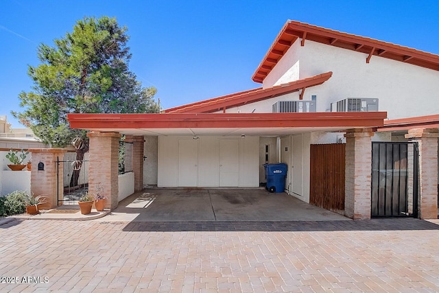 rear view of property featuring central AC and a carport