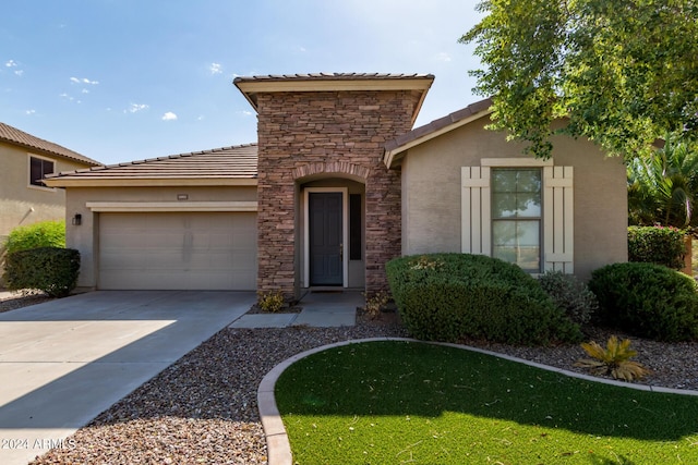 view of front facade featuring a tile roof, stucco siding, concrete driveway, an attached garage, and stone siding