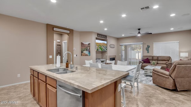 kitchen featuring a center island with sink, recessed lighting, light countertops, open floor plan, and a sink