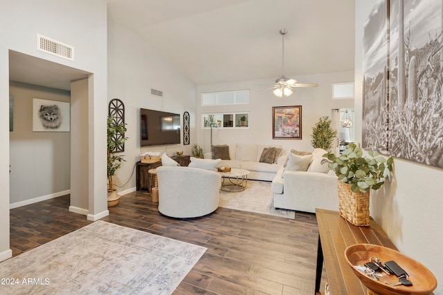 living room with a healthy amount of sunlight, ceiling fan, dark wood-type flooring, and high vaulted ceiling