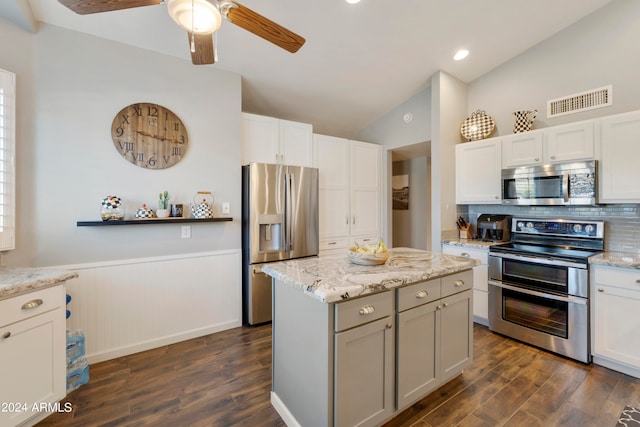 kitchen with ceiling fan, white cabinets, dark wood-type flooring, stainless steel appliances, and vaulted ceiling