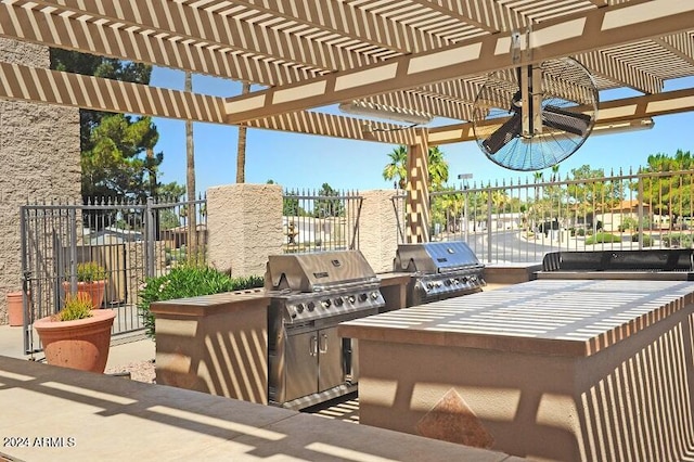 view of patio / terrace with area for grilling, a pergola, and exterior kitchen