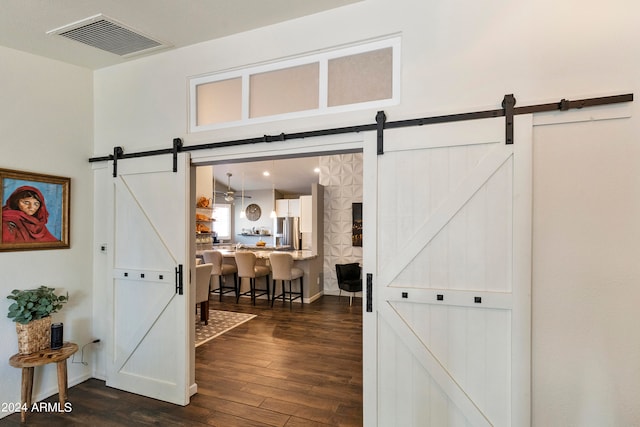 corridor featuring dark hardwood / wood-style flooring and a barn door