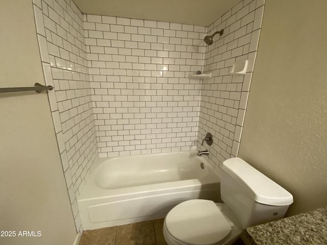 bathroom with toilet, washtub / shower combination, and a textured wall