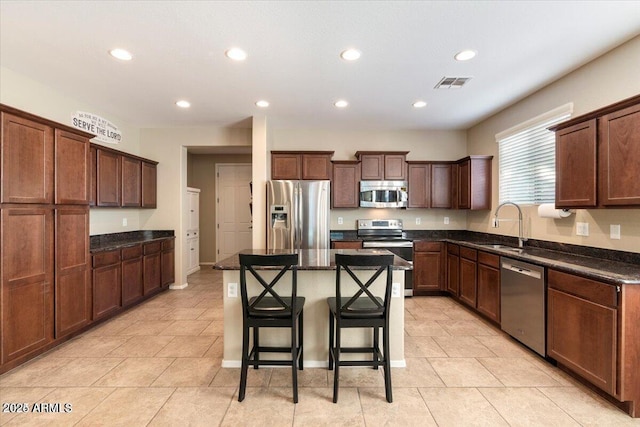 11048 E Quintana Ave, Mesa, AZ 85212 - kitchen featuring stainless steel appliances, recessed lighting, a kitchen breakfast bar, a kitchen island, and dark stone countertops
