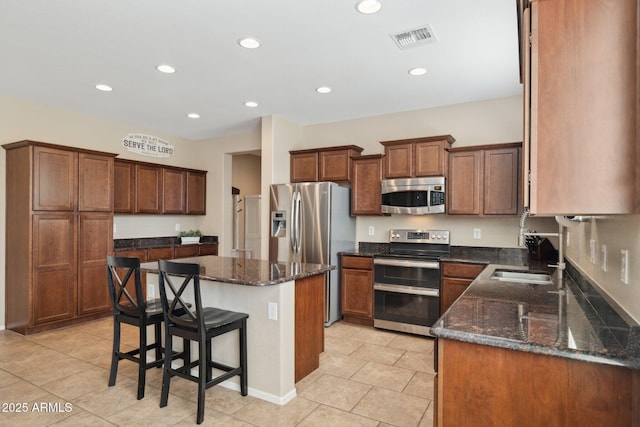 11048 E Quintana Ave, Mesa, AZ 85212 - kitchen with stainless steel appliances, recessed lighting, a kitchen island, dark stone countertops, and light tile patterned floors