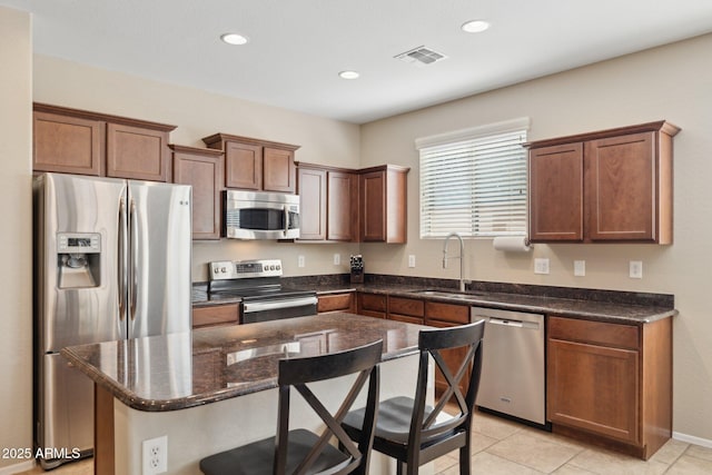 11048 E Quintana Ave, Mesa, AZ 85212 - kitchen with appliances with stainless steel finishes, a kitchen bar, a kitchen island, recessed lighting, and dark stone countertops