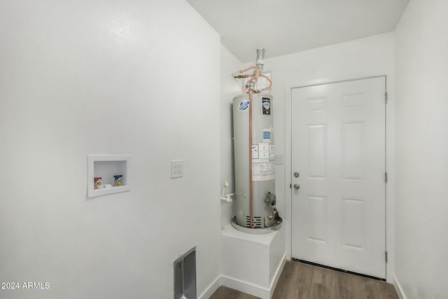 washroom featuring washer hookup, dark hardwood / wood-style floors, and gas water heater