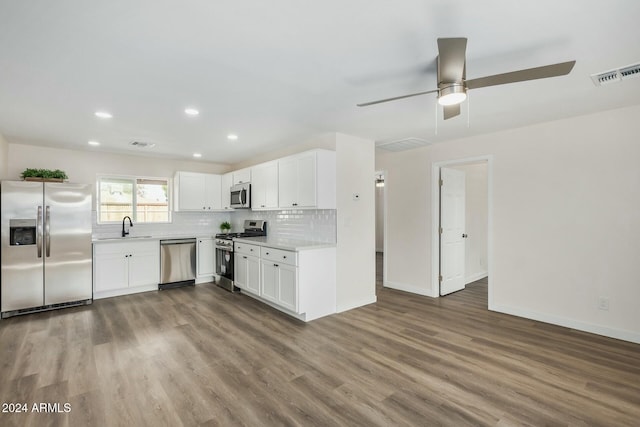 kitchen with white cabinets, stainless steel appliances, tasteful backsplash, sink, and ceiling fan