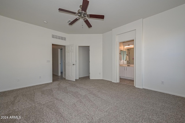 unfurnished bedroom featuring ceiling fan, ensuite bathroom, and carpet flooring