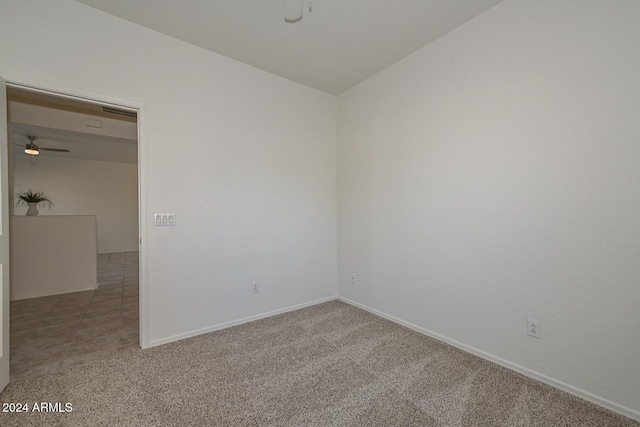 carpeted spare room with ceiling fan