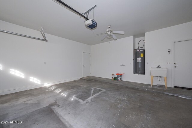 garage featuring sink, a garage door opener, ceiling fan, and water heater