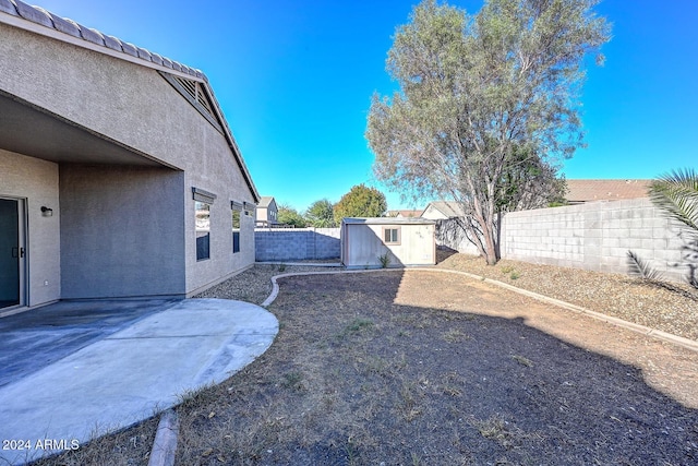 view of yard with a storage shed and a patio area