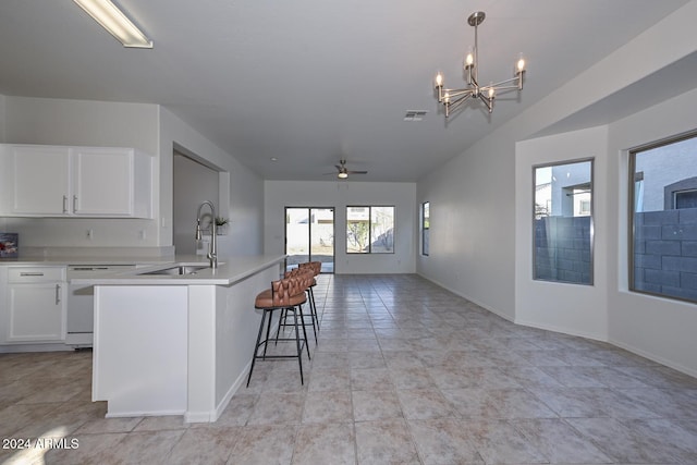 kitchen with white cabinetry, sink, white dishwasher, hanging light fixtures, and ceiling fan with notable chandelier