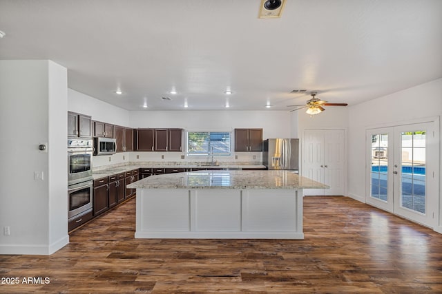 kitchen with french doors, stainless steel appliances, a kitchen island, and dark hardwood / wood-style floors