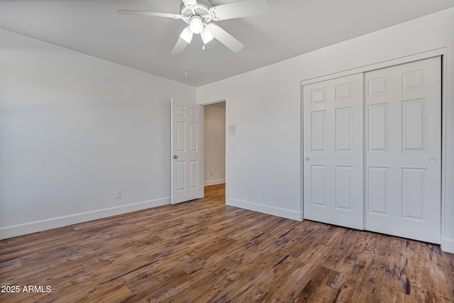 unfurnished bedroom with dark hardwood / wood-style flooring, a closet, and ceiling fan