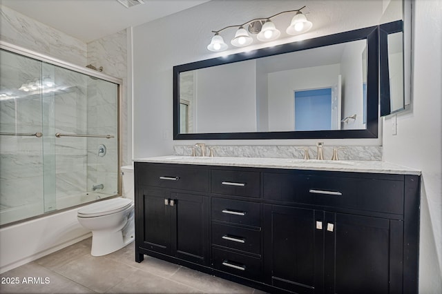 full bathroom with tile patterned floors, vanity, toilet, and shower / bath combination with glass door