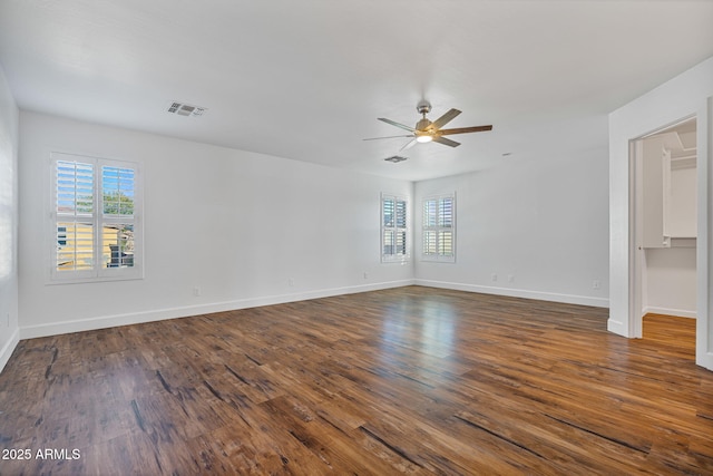 empty room with ceiling fan and dark hardwood / wood-style flooring