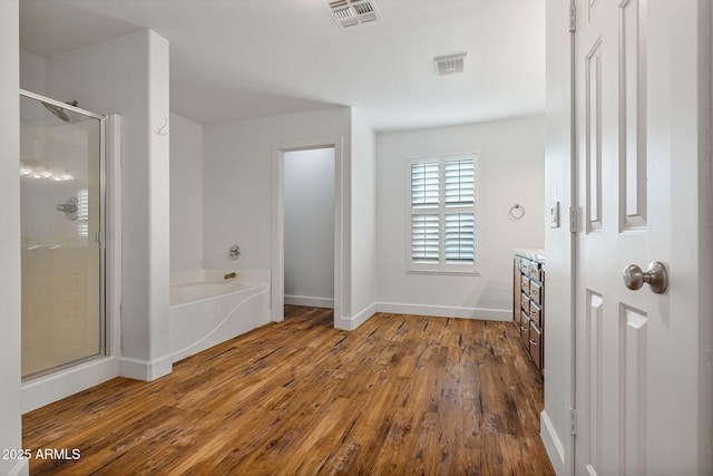 bathroom featuring vanity, hardwood / wood-style floors, and plus walk in shower