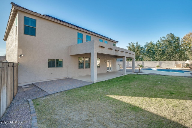 rear view of house featuring a fenced in pool, a patio area, and a yard