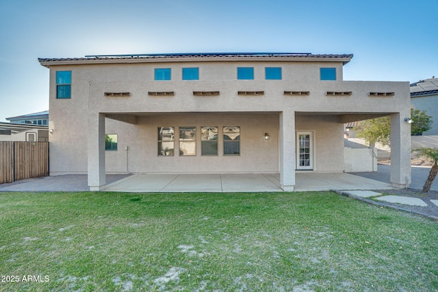 back of house featuring a lawn and a patio